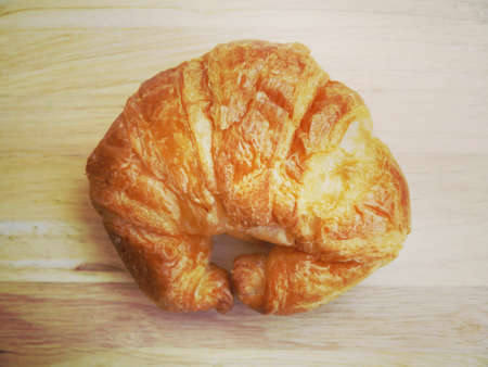 Fresh Croissants on wooden with retro filter effect