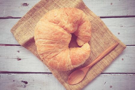 Fresh Croissants on wooden with retro filter effectの写真素材