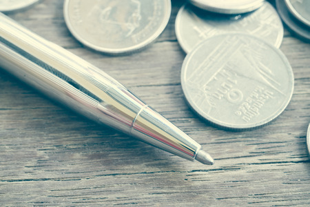 Pen and coins with filter effect retro vintage styleの写真素材