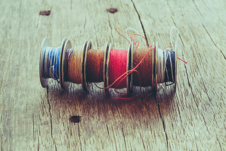 thread rolls on wood background with filter effect retro vintage style