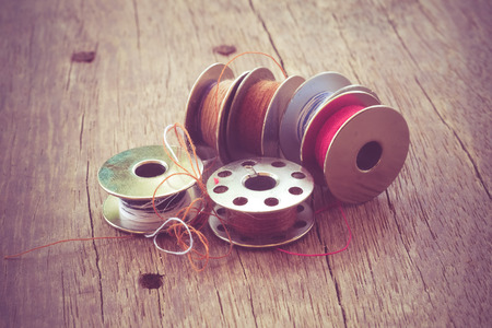 thread rolls on wood background with filter effect retro vintage styleの写真素材