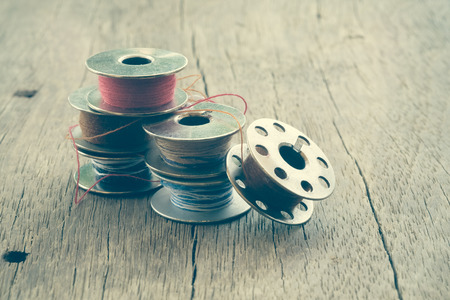 thread rolls on wood background with filter effect retro vintage styleの写真素材