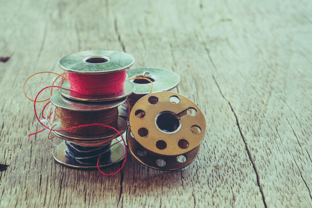 thread rolls on wood background with filter effect retro vintage styleの写真素材