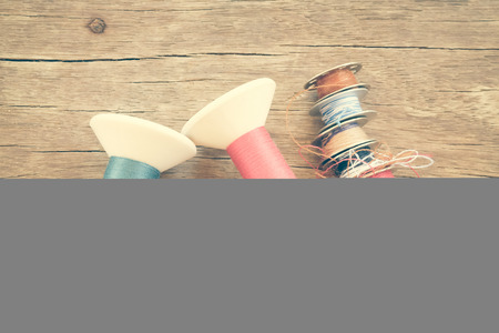 thread rolls on wood background with filter effect retro vintage style