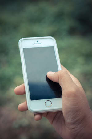 Woman hand holding smartphone  with filter effect retro vintage styleの写真素材