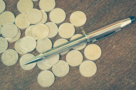Pen and coins with filter effect retro vintage styleの写真素材