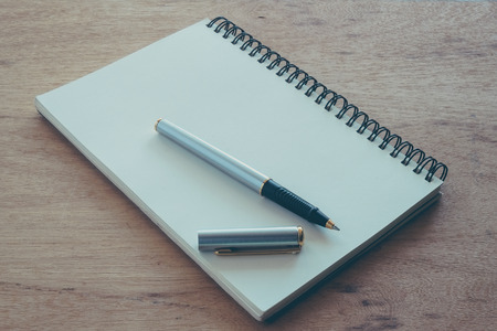 paper notebook and pen on a table with filter effect retro vintage styleの写真素材