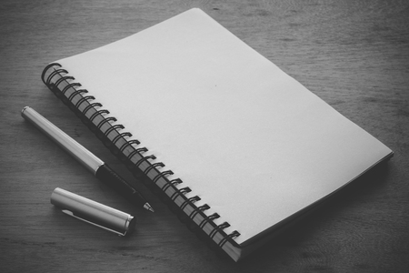 paper notebook and pen on a table with filter effect retro vintage styleの写真素材