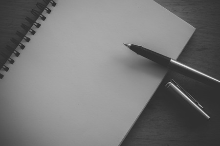 paper notebook and pen on a table with filter effect retro vintage styleの写真素材