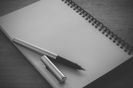 paper notebook and pen on a table with filter effect retro vintage styleの写真素材