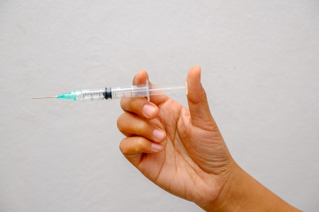 Hand holding syringe with filter effect retro vintage styleの写真素材