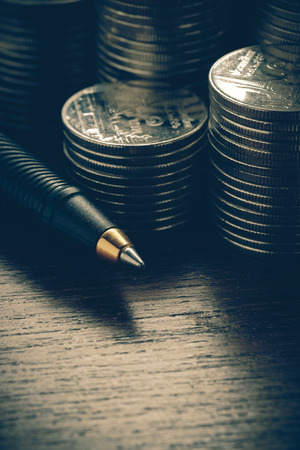 money concept coins and pen with filter effect retro vintage styleの写真素材
