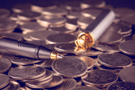 money concept coins and pen with filter effect retro vintage styleの写真素材