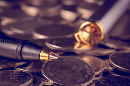 money concept coins and pen with filter effect retro vintage styleの写真素材