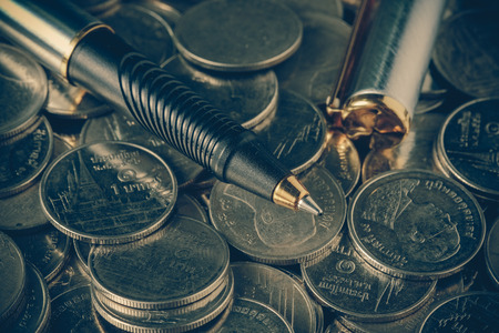 money concept coins and pen with filter effect retro vintage styleの写真素材