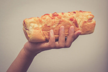 Hand holding bread  with hand with filter effect retro vintage styleの写真素材