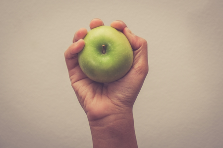 Hand holding green apple with hand with filter effect retro vintage styleの写真素材