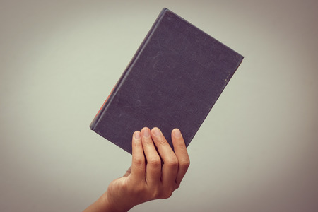 hands holding old book with filter effect retro vintage styleの写真素材
