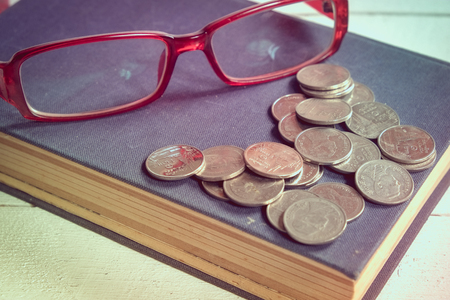 Old books and glasses on a wooden table with filter effect retro vintage styleの写真素材