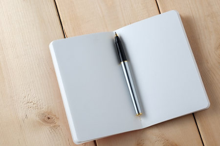 pen and book on wood backgroundの写真素材