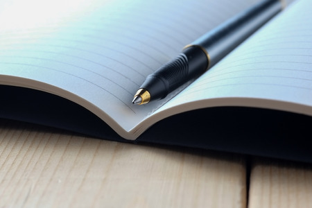 pen and book on wood backgroundの写真素材