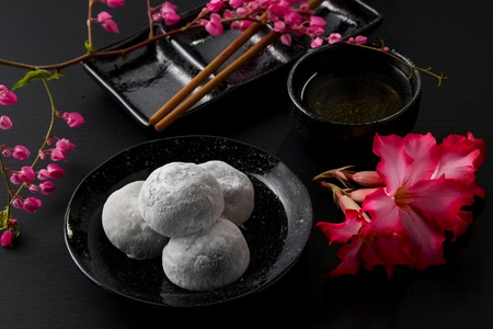 Japanese sweet black sesame daifuku on black wooden backgroundの写真素材