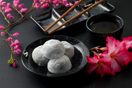 Japanese sweet black sesame daifuku on black wooden backgroundの写真素材
