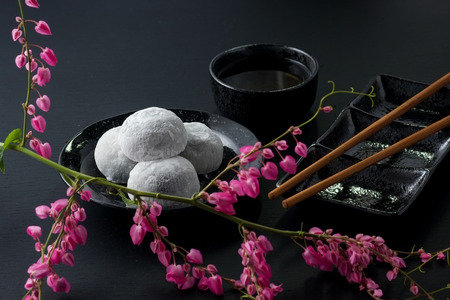 Japanese sweet black sesame daifuku on black wooden backgroundの写真素材