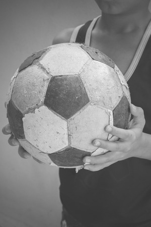 Children hold the old football with filter effect blabk and white styleの写真素材