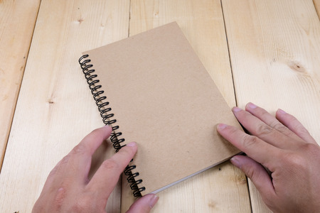 Hands hold book on wood tableの写真素材