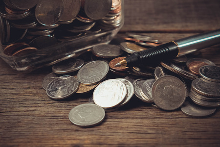money concept coins and pen with filter effect retro vintage styleの写真素材