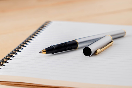 pen and book on wood backgroundの写真素材