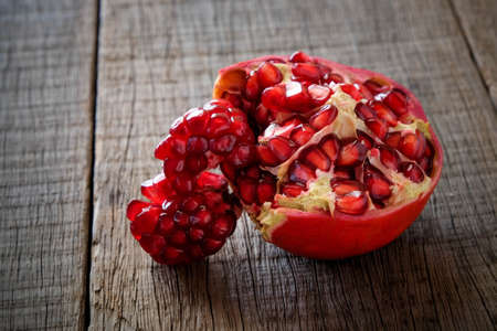 Ripe pomegranate fruit on wooden vintage background.