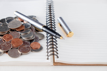 business finance. save money for investment concept coins and pen