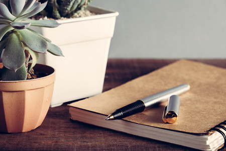 pen and book on wood background with filter effect retro vintage styleの写真素材