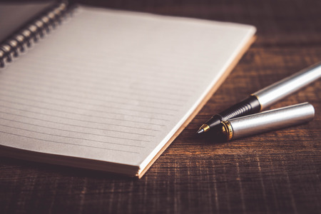 pen and book on wood background with filter effect retro vintage styleの写真素材