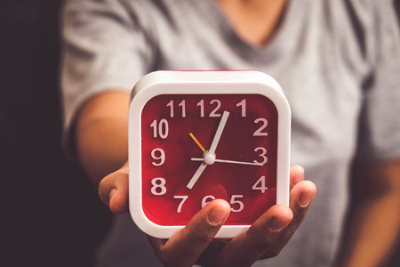 hand holding Alarm clock with filter effect retro vintage style