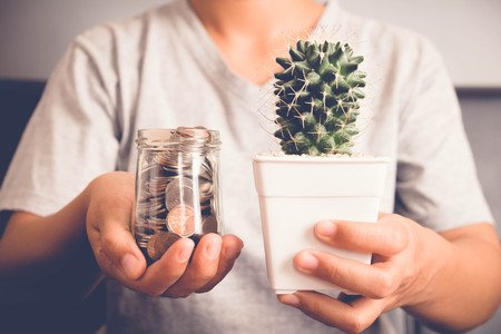 save money for investment concept Hand holding money in jar with filter effect retro vintage style