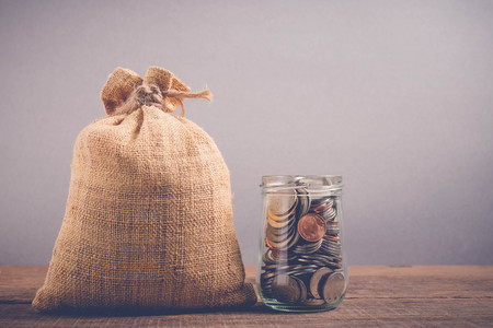 save money for investment concept money in the glass jar with filter effect retro vintage styleの写真素材