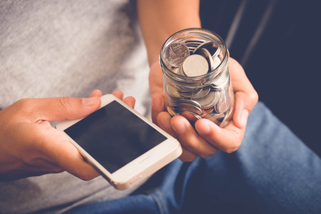 save money for investment concept Hand holding money in jar with filter effect retro vintage style