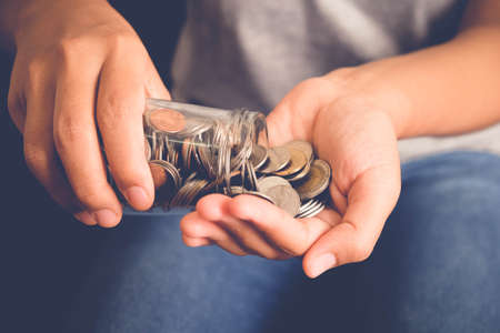save money for investment concept Hand holding money in jar with filter effect retro vintage style