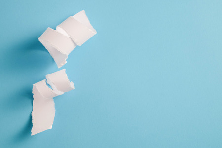 white torn paper with blue background, ready for designの写真素材