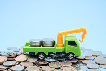 save money for investment concept truck toy and Coins on blue backgroundの写真素材