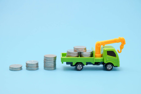 save money for investment concept truck toy and Coins on blue backgroundの写真素材