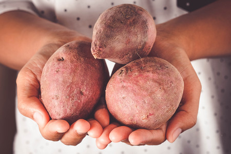 Raw sweet potatoes on wood background with filter effect retro vintage styleの写真素材