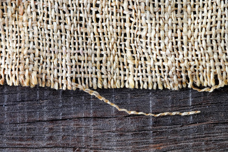 Wood table with old sackcloth burlap tablecloth textureの写真素材
