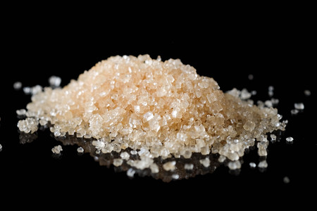 Crystals Sugar,Brown cane sugar isolated on black backgroundの写真素材