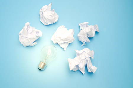 great concept with crumpled office paper and light bulb on a blue background