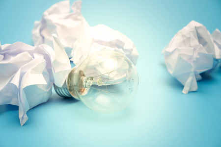 great concept with crumpled office paper and light bulb on a blue backgroundの写真素材