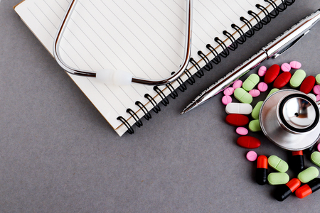 Medical equipments including stethoscope, prescription medicines background, top view flat layの写真素材